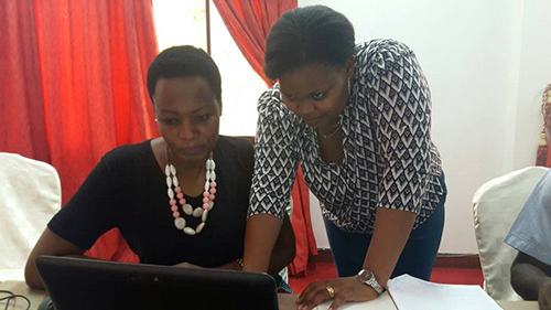 NCA's PMER, Mwajuma Davina Rwebangila assists Manka Kway, Director of Human Resources for one of NCA’s core partner Tanzania Episcopal Conference.
