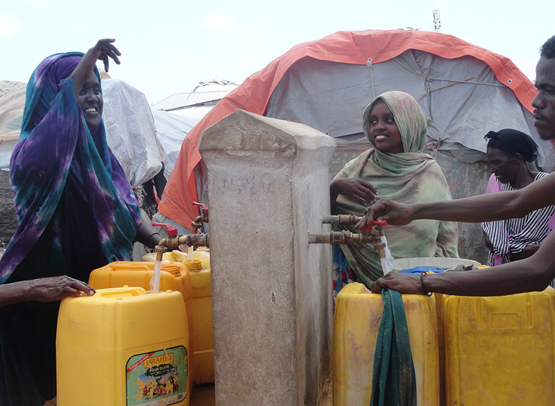 Men and women from IDP settlements enjoy a new water point with clean and safe water in Zone K Mogadishu. Photo: Bani’adam Organization