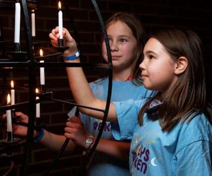 barn som tenner lys i kirke