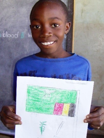 Ung smilende gutt som holder opp en tegning