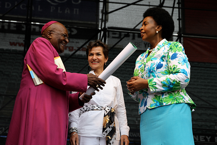 Erkebiskop Desmond Tutu overleverer 200 000 underskrifter til COP-president Maite Nkoana-Mashabane og sjefen for klimaforhandlingene Christiana Figueres i 2012. En del av underskriftene kom fra Norge og kampanjen Kirkens Nødhjelp gjennomførte.  Foto: Bergit Sønsteby/Kirkens Nødhjelp 