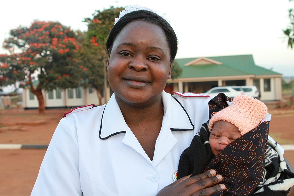 Et barn er født:  En av sykepleierne på Lunjika Health Clinic holder et nyfødt barn i armene. Helseklinikken ble åpnet i 2014 med støtte fra KN.  