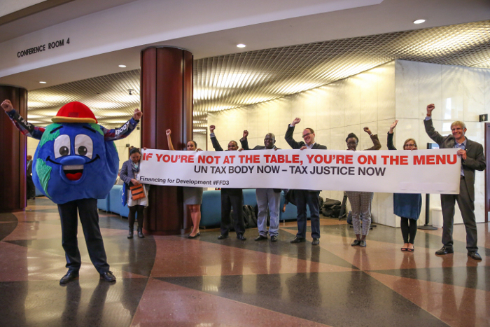Demonstranter aksjonerer for et skatteorgan under et FN møte i 2015. Foto: IISD.