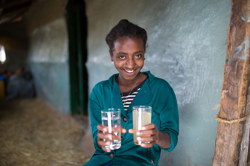 Før og etter: Takket være støttespillere som deg, har Tizibit (12) og 5 700 innbyggere i Derefo i Etiopia fått tilgang til rent vann. I høyre glass ser du vannet fra dammen hvor hun tidligere hentet drikkevannet sitt fra.