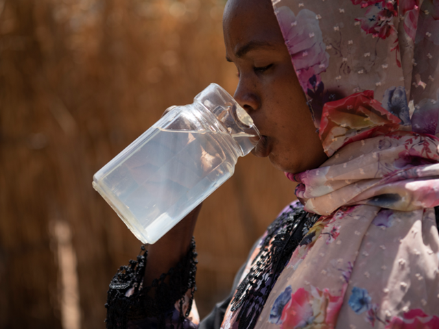 En kvinne som drikker vann