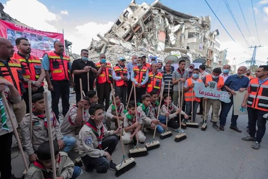 Youth volunteers chant "We will rebuild" as they line up to help clear the streets of Gaza. Photo credit: NCA/DCA.