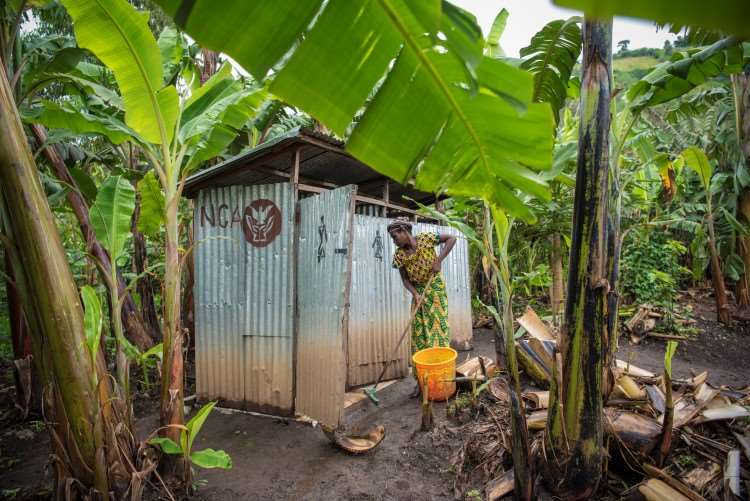 Kvinne som står utenfor en do Kirkens Nødhjelp har vært med på å bygge i Kongo