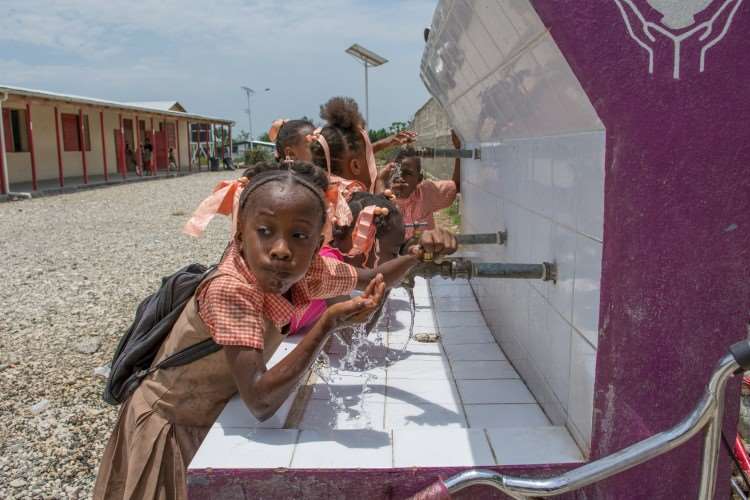 Barn som drikker vann i Haiti i uniform